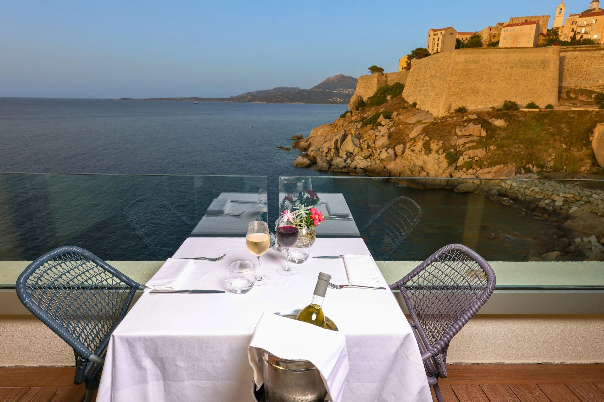 Tables dressées dans le restaurant avec vue imprenable sur la mer à l'Hôtel Saint-Christophe en Haute-Corse