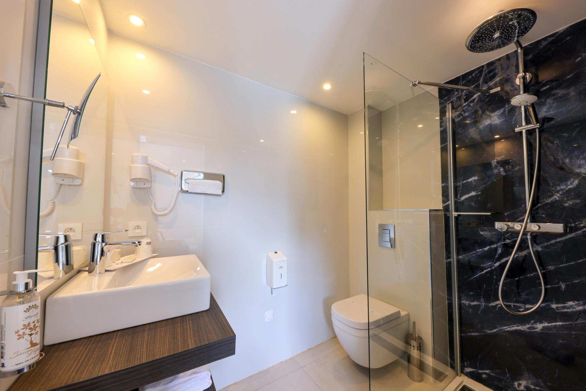 Salle de bain moderne attenante à une chambre Supérieure avec vue mer frontale en Balagne